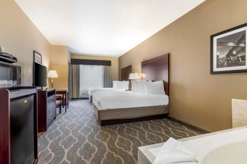 a hotel room with two beds and a television at Best Western Plus Burleson Inn & Suites in Burleson