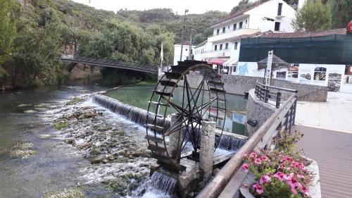 a river with a watermill next to a bridge at Quinta Da Silva in Vale dos Ovos