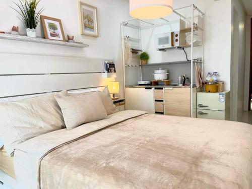 a bedroom with a large bed and a kitchen at 3D's One PonteFino Tower in Batangas City