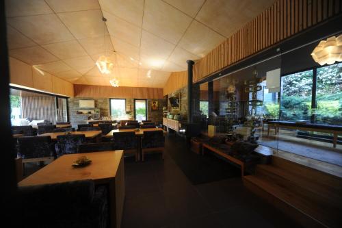 a restaurant with wooden tables and chairs and windows at Rio Moment's in Castelo de Paiva