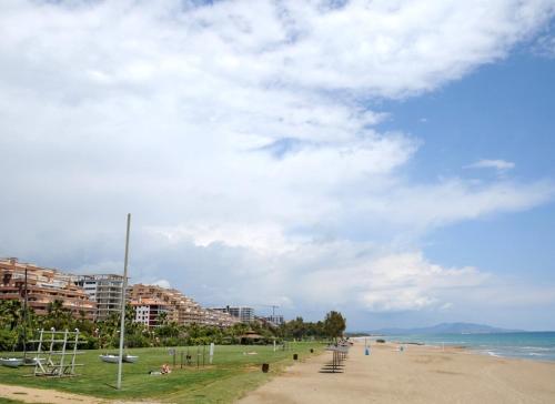 a beach with buildings and people on the sand at Apartalux Magic Diamond in Oropesa del Mar