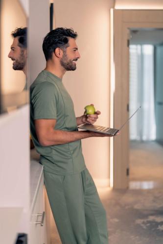 a man standing in a kitchen holding a laptop at Radisson Blu Hotel Riyadh Convention and Exhibition Center in Riyadh