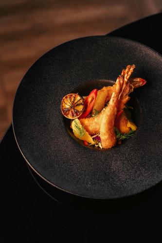 a plate of food with fish and a lemon at Radisson Blu Hotel Riyadh Convention and Exhibition Center in Riyadh
