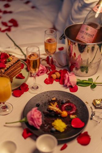 a table with a plate of food and two glasses of wine at Radisson Blu Hotel Riyadh Convention and Exhibition Center in Riyadh