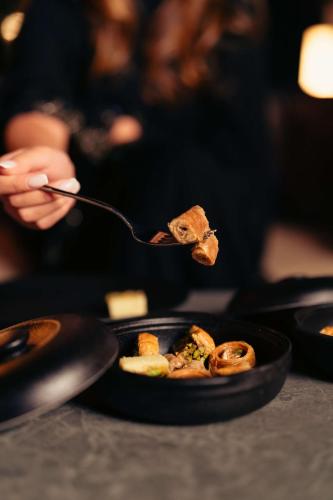 a person is eating food on a spoon at Radisson Blu Hotel Riyadh Convention and Exhibition Center in Riyadh
