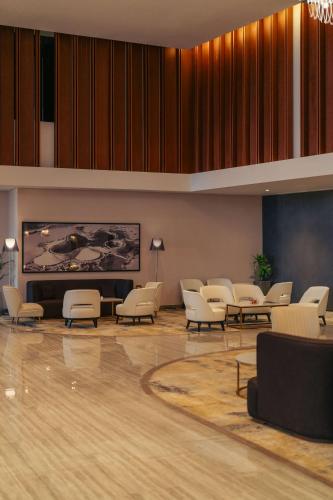 a waiting room with chairs and a large screen at Radisson Blu Hotel Riyadh Convention and Exhibition Center in Riyadh