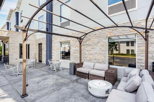 a patio with couches and a table and chairs at Best Western Plus Bourbonnais Hotel & Suites in Bourbonnais