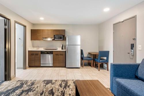 a kitchen and living room with a refrigerator and a table at Best Western Plus Bourbonnais Hotel & Suites in Bourbonnais
