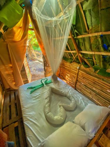 a statue of an elephant laying on a bed at Green House Chalé, hostel e pousada in Saquarema