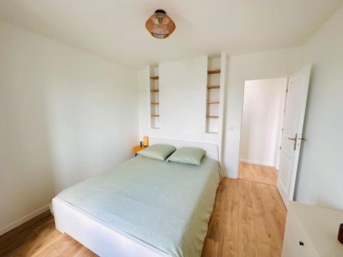 une chambre blanche avec un lit et une fenêtre dans l'établissement Cosy Sunny Saint-Denis, à Saint-Denis