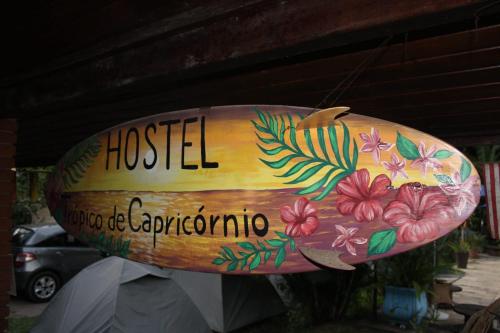 a sign that says hostel with flowers on it at Hostel Trópico de Capricórnio - Tenório in Ubatuba