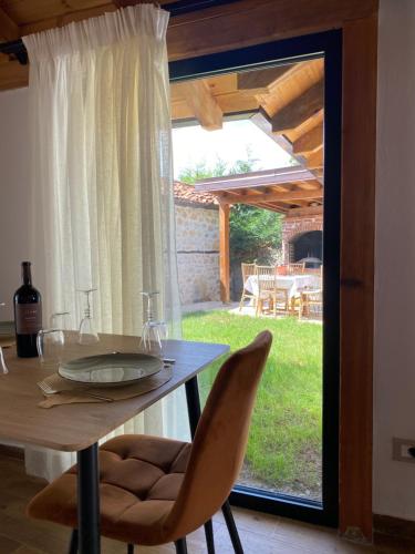 a dining table and chairs with a view of a yard at Vileta Auri in Tushemisht