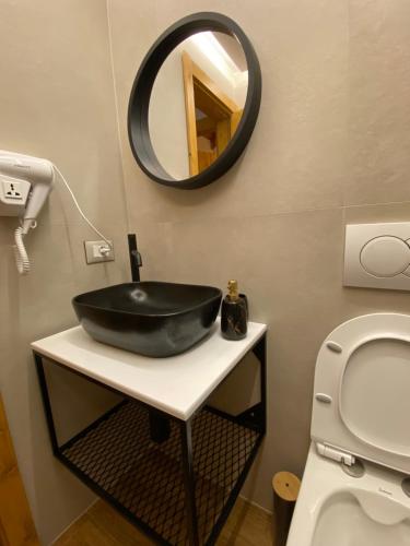 a bathroom with a black sink and a mirror at Vileta Auri in Tushemisht