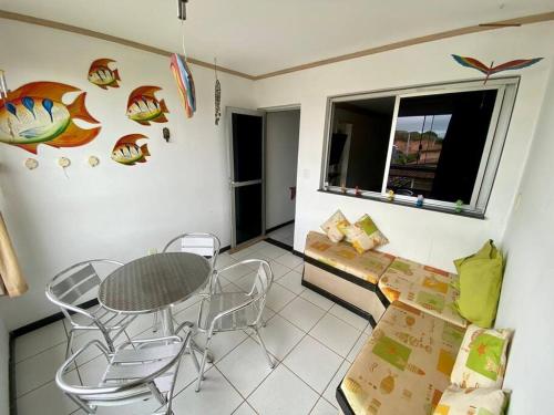 a living room with a table and chairs and a window at Apartamento Castelhanos ES in Anchieta