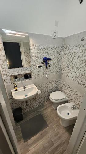 a bathroom with a sink and a toilet and a mirror at Gliù Vico in Formia