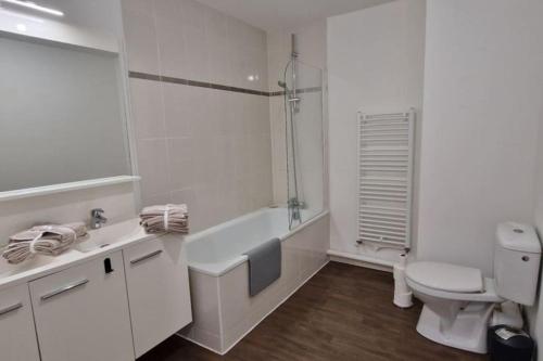 une salle de bain blanche avec des toilettes et un lavabo dans l'établissement Appartement ensoleillé, à Les Sables-dʼOlonne