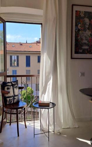 a room with a chair and a table and a window at Mini appartamento a Monza in Monza