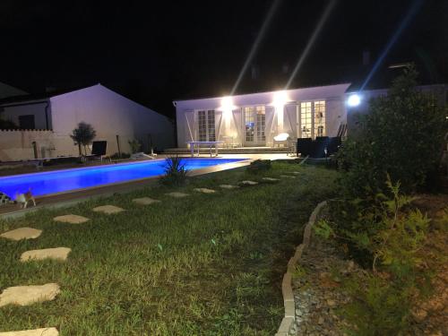 une maison avec piscine la nuit dans l'établissement Maison bord de mer avec piscine 10m chauffée classée 3 étoiles, à La Brée-les-Bains