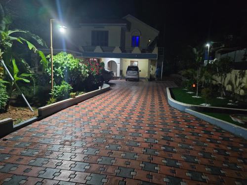 a brick driveway in front of a house at night at Surabhi-Nature Villa ,En Route Varkala,Jatayu,Attingal in Trivandrum