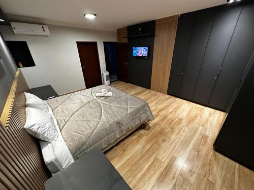 a bedroom with a bed and a television in it at Casa Alto da Serra in Serra Negra