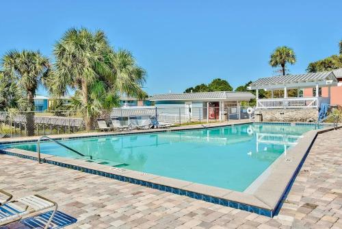 a swimming pool with palm trees and a house at Cool Azul 3 Community Pools Central Destin in Destin