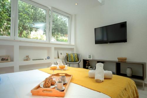 een slaapkamer met een bed en een dienblad met eten en wijnglazen bij Studio Kai - ZF Hvar in Hvar