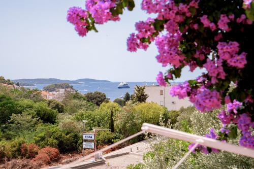 uitzicht op het water en bomen met roze bloemen bij Studio Kai - ZF Hvar in Hvar