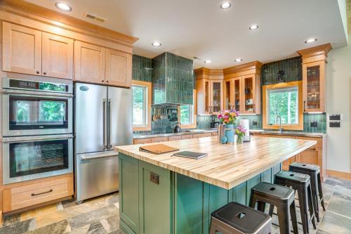 a kitchen with wooden cabinets and stainless steel appliances at Modern Nellysford Getaway with View Deck and Fire Pit in Nellysford