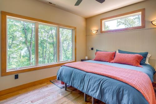 a bedroom with a bed and two windows at Modern Nellysford Getaway with View Deck and Fire Pit in Nellysford