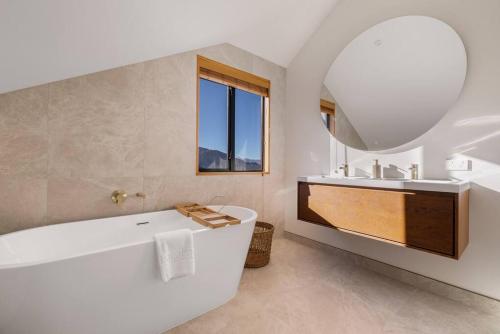 une salle de bain blanche avec une baignoire et un lavabo dans l'établissement Fabulous Home with Great Views, à Queenstown