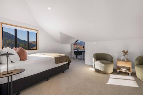 une chambre avec un lit, deux chaises et une fenêtre dans l'établissement Fabulous Home with Great Views, à Queenstown