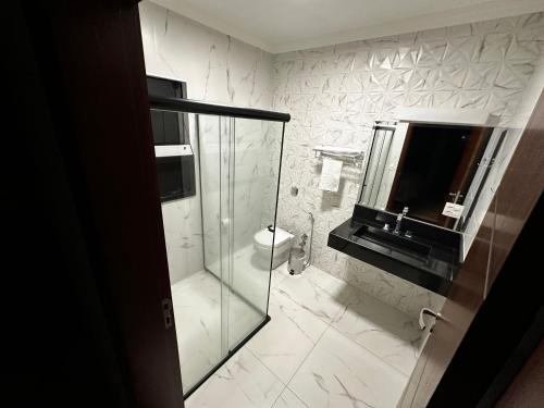 a bathroom with a glass shower and a toilet at Casa Alto da Serra in Serra Negra