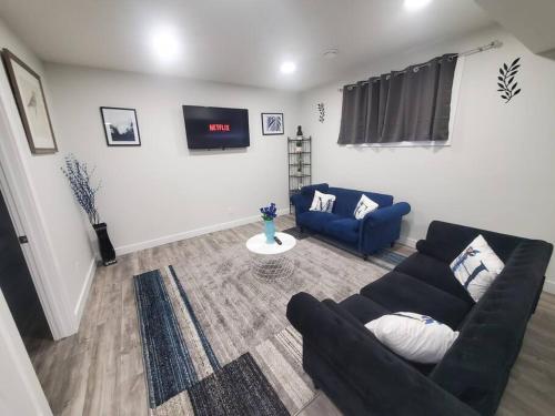 a living room with a couch and a tv at Charming 2-Bedroom Basement Oasis Sleeps 5,Size-150sqm, Netflix, family friendly in Edmonton