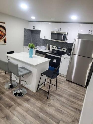 a kitchen with a refrigerator and a table and chairs at Charming 2-Bedroom Basement Oasis Sleeps 5,Size-150sqm, Netflix, family friendly in Edmonton