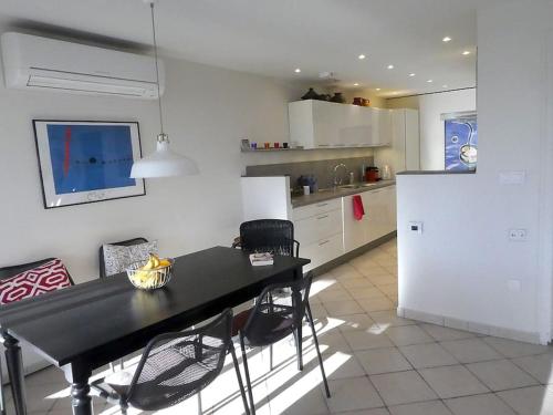 La cuisine est équipée d'une table et de chaises noires ainsi que d'un réfrigérateur. dans l'établissement Laroque-des-Alberes Stunning 3 bed villa, sunny terrace & great views, à Laroque-des-Albères