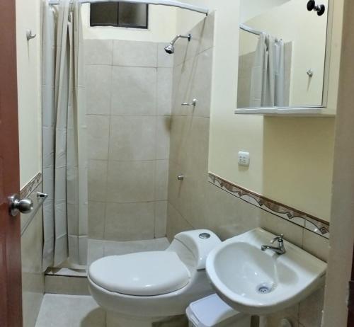 a bathroom with a toilet and a sink and a shower at Departamentos las Palmeras in Tarapoto