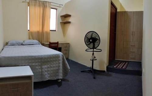 a bedroom with a bed and a fan at Departamentos las Palmeras in Tarapoto