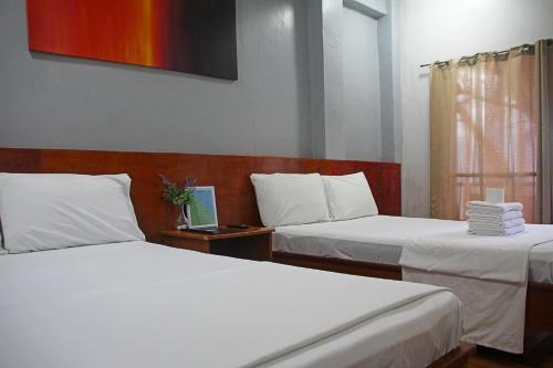 a room with two beds and a laptop on a table at Sea View Resort in Siquijor