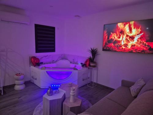 a living room with a couch and a tv on a wall at Love Room - Cocon Room - Toulon - Ollioules in Ollioules