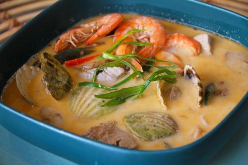 a blue bowl of soup with seafood and vegetables at Sea View Resort in Siquijor
