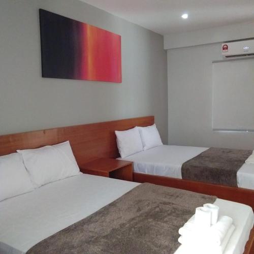 a hotel room with two beds and a tv on the wall at Sea View Resort in Siquijor