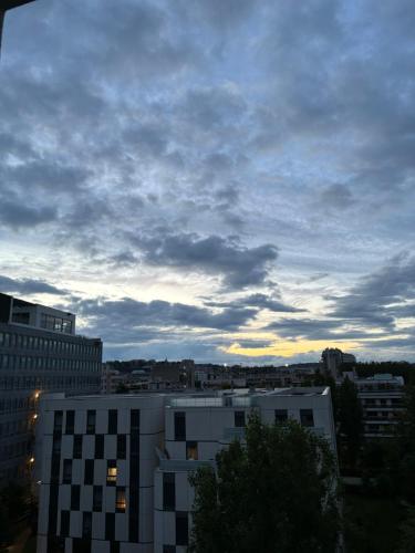 un ciel nuageux au-dessus d'une ville avec un bâtiment dans l'établissement Paris-Boulogne studio, à Boulogne-Billancourt