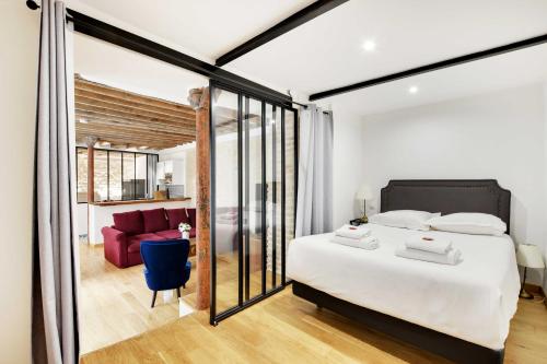 - une chambre avec un grand lit blanc et un canapé rouge dans l'établissement Appartement Chic au Cœur du 9ème 2 chambres 6P, à Paris