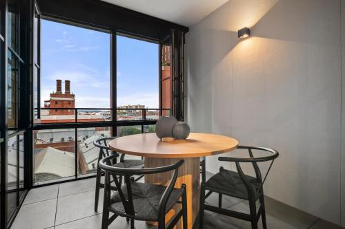 a table and chairs in a room with a large window at Modern, Luxury Retreat with Gym and Pool in Melbourne