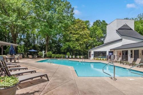 a swimming pool with lounge chairs and a building at Deluxe luxury & convenience in Charlotte