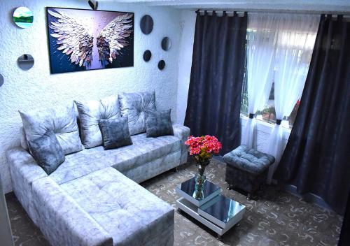 a living room with a couch and a vase of flowers at Casangel Hogar Familiar en Sector Exclusivo cerca al Aeropuerto Local frente al Poblado in Medellín