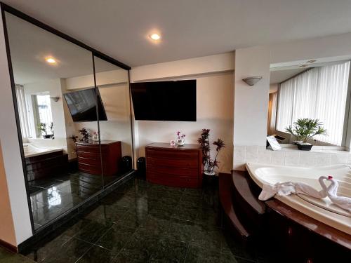 a large bathroom with a tub and a tv at Hotel Boulevard in Lima