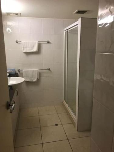 a bathroom with a shower and a sink at Osprey Apartments in Mooloolaba