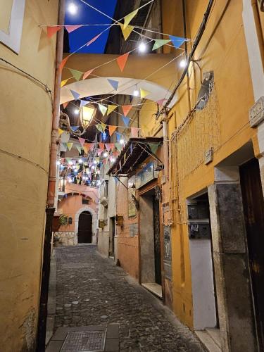 an alley with flags hanging from the ceiling of a building at Gliù Vico in Formia
