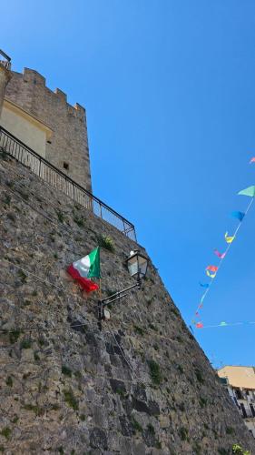 a castle with a flag on the side of a wall at Gliù Vico in Formia